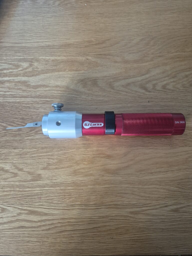 Electric Pick gun in red laid on wooden oak background 